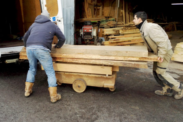 Furniture maker loading the van with oak planks from the sawmill