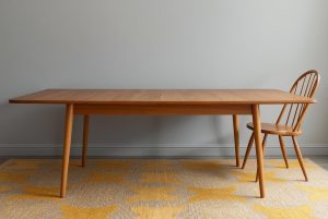 1960s style Ercol table fully extended together with a wooden spindle back ercol style chair