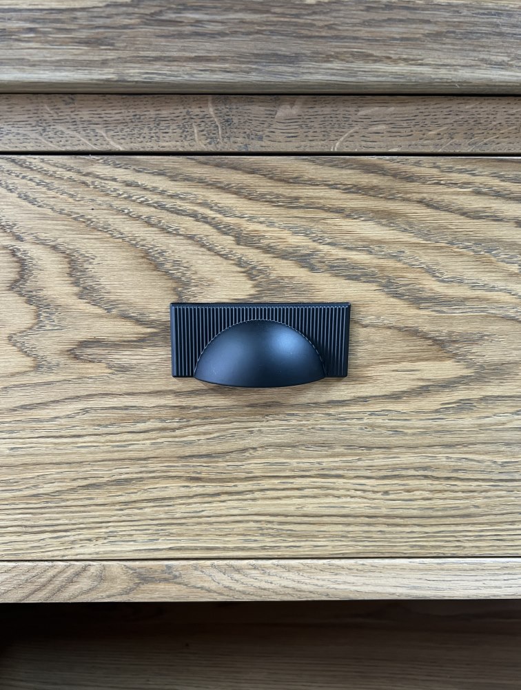 Matt black modern metal cup handles on oak cabinetry