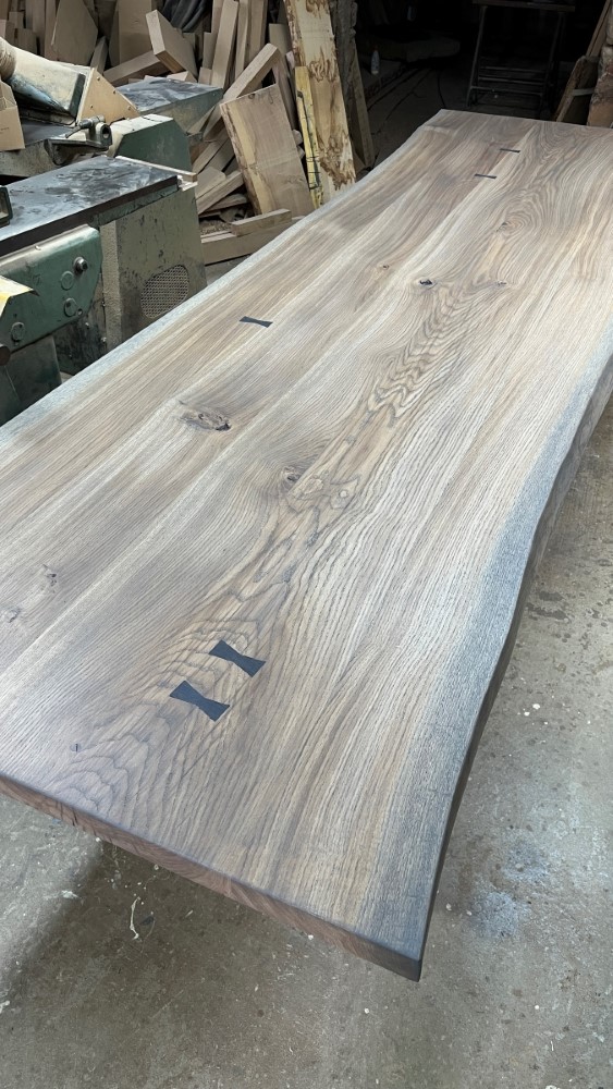 Custom made waney edge dining table with butterfly joins and a tinted oil finish